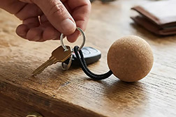 Llavero Floating. Llavero flotante de diseño esférico, diseñado específicamente para actividades náuticas y deportes acuáticos. Está fabricado con un cuerpo principal de corcho natural, lo que le otorga su característica capacidad de flotación, y se complementa con un aro y accesorios de acero inoxidable 304, garantizando resistencia a la corrosión en entornos acuáticos. Incluye una cuerda de alta resistencia para asegurar una sujeción firme. Sus medidas exactas son de 5,1 cm de altura por 5,1 cm de profundidad. Cada unidad se entrega en un empaque individual de bolsa. Resulta un accesorio liviano, práctico e indispensable para la seguridad de llaves en embarcaciones y entornos de agua, siendo una excelente opción promocional para el sector náutico. - 2
